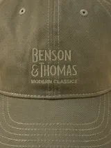 Gorra de gabardina color verde militar con visera curva y logo bordado en el frente. Ajuste trasero con hebilla metálica.