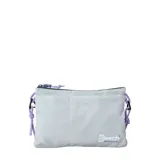 Bolso de mano tipo sobre o cartera Rip Curl The Search Crossbody, color celeste pálido con textura ripstop. Presenta un bolsillo frontal exterior y cierre superior con tiradores de cordón morado. Incluye logo de 'Search RIPCURL' en la parte inferior derecha.