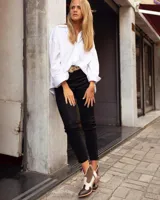 Botines de cuero marrón y blanco con diseño western, puntera redondeada y cierre lateral con cremallera. El talón tiene una tira de cuero para facilitar el calce.