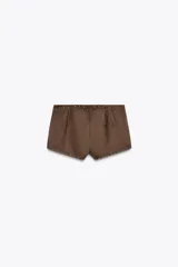 Shorts de tiro alto color marrón, confeccionados en tejido efecto ante con aplicación de tachas doradas. Cierre lateral con cremallera oculta.