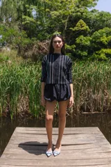 Cardigan tejido con lurex a rayas verticales en tonos negro, blanco, azul y fucsia, con botones en la delantera y mangas 3/4.