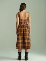 Vestido midi marrón a cuadros con breteles anchos, espalda semi-baja y cordones ajustables en la parte superior.
