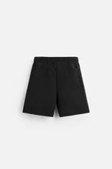 Bermuda negra relaxed fit confeccionada en tejido interlock de algodón con elasticidad. Cintura elástica ajustable con cordón. Bolsillos laterales y detalle de bolsillo trasero de plastrón.