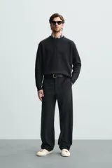 Jersey negro de punto con cuello redondo y manga larga. Presenta parches combinados en hombros y codos.