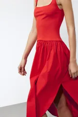 Vestido midi rojo de escote cuadrado y tirantes anchos. Detalle de bajo redondeado en tejido combinado a tono.