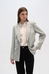 Blazer gris claro con rayas verticales finas, cuello con solapa, cierre con dos botones, bolsillos laterales con solapa y corte holgado.