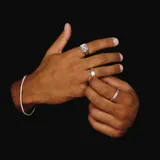 Anillo plateado de metal con forma irregular y textura martillada.