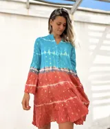 Vestido camisero corto con estampado batik en tonos turquesa y terracota con detalles dorados, cuello mao y mangas 3/4 acampanadas.