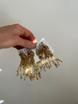 Aros colgantes hechos a mano con bronce, porcelana, piedras y otros materiales que le dan textura. Cada par es único e irregular.