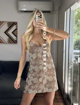 Vestido corto marrón con estampado de flores blancas, escote en V y tirantes finos.