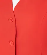 Chaleco de vestir color blanco hueso, con escote en V, cierre frontal con botones y espalda abierta. Corte sastrero.