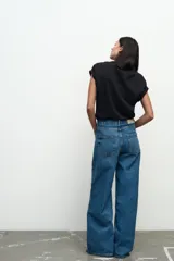Jeans de tiro medio, color azul denim, con cinco bolsillos, corte wide leg y largo extra.