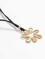 Collar con cordón negro y dije de flor plateada.