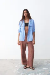 Camisa celeste de lino con mangas 3/4 y dos bolsillos frontales.