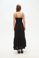 Vestido largo negro de bretel lencero, con escote en V, corte holgado, tajo lateral y detalle de argolla en el busto.