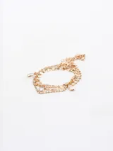 Set de cuatro pulseras doradas con dijes de strass y cuentas de cristal.