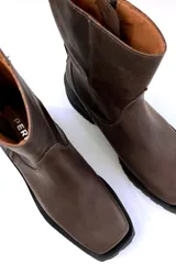 Bota de cuero color chocolate con cierre lateral, diseñada para un calce cómodo.