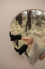Botas negras de cuero con flecos y taco bajo.
