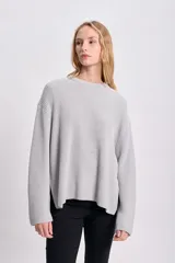 Sweater gris de punto inglés con cuello redondo y mangas largas.