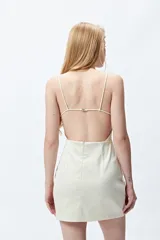 Vestido corto negro de breteles finos con escote en V, silueta entallada y espalda completamente abierta con ajuste metálico.