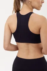 Top deportivo negro al cuello, de gran soporte en pecho y espalda, con alta compresión y padding desmontable.