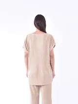 Blusa negra de corte holgado y mangas cortas, con textura plisada.