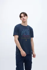 Remera azul con estampa central con texto en celeste y rojo, y una estrella dorada. Tiene un pequeño estampado en la espalda. Corte clásico y mangas cortas.