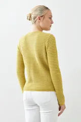 Chaqueta tejida roja con botones metálicos dorados y cuello redondo.