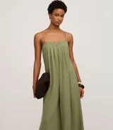 Mono de mujer color verde oliva, de pierna ancha y tiro alto, con escote recto y fruncidos en el busto. Los breteles son finos y trenzados en dos tonos.