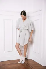 Bata corta color gris melange, con cuello en V, mangas cortas amplias y lazo para ajustar en la cintura.