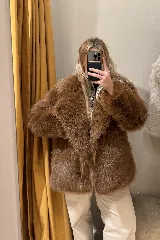 Campera de pelo sintético color beige, con cuello solapa, cierre con botones y bolsillos laterales.