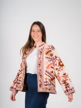 Chaqueta color crema con bordados florales en tonos tierra, rojizos y morados.