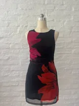 Vestido corto negro con estampado de flores rojas, confeccionado en microtul forrado.