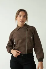 Campera cropped de textura tipo gamuza, con cierres metálicos y diseño entallado.
