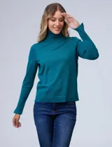 Polera de punto fino marca Nienty, color blanco, con cuello alto volcado y mangas largas con detalle de tajo en los puños.