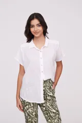 Camisa blanca de manga corta, con botones frontales y corte holgado.