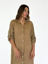 Vestido camisero largo color beige, con cuello clásico, abotonadura frontal completa, mangas 3/4 con trabilla y aberturas laterales.