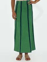 Pollera larga de jean azul con corte acampanado y costuras verticales en color ladrillo.