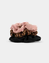 Set de tres scrunchies de tela plisada: uno rosa, uno con estampado animal print y uno negro.