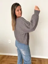 Sweater de tejido calado color gris, con cuello redondo y mangas globo.