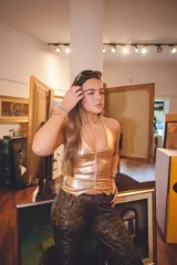 Top chaleco dorado con escote en V y breteles que se atan en el cuello.