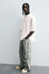 Pantalón relaxed fit de denim negro con efecto lavado, bolsillos frontales, traseros de plastrón y multifunción en perneras. Bajo ajustable con trabilla y cierre frontal con cremallera y botón.