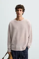 Jersey color verde claro de punto tejido en hilatura ligera de lino, corte relaxed fit, cuello redondo y manga larga con terminaciones en rib.