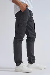 Pantalón cargo gris oscuro de corte slim, con bolsillos laterales con fuelle y solapa con botón a presión.