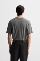 Camiseta gris de corte recto, cuello redondo y manga corta.