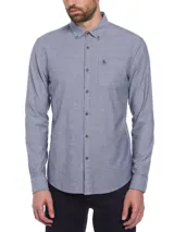 Camisa de manga larga celeste con botones marrones, bolsillo en el pecho y logo de pingüino bordado.