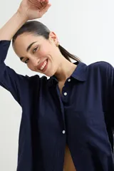 Camisa color beige de corte amplio, con cuello clásico, manga larga y bolsillo en el pecho.