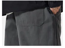 Pantalón cargo negro de corte ancho, confeccionado en gabardina de algodón. Presenta cintura elástica y regulable con cordón blanco, y múltiples bolsillos cargo laterales con costuras destacadas.