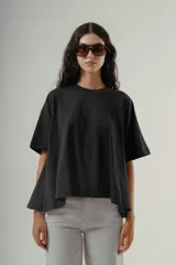 Camiseta negra de algodón con corte amplio y mangas cortas. Presenta un pequeño bordado sutil en el pecho.