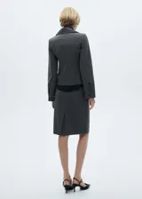 Falda midi de corte lápiz color gris oscuro con finas rayas verticales, cinturón desmontable y abertura en el bajo.